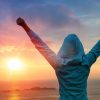 person cheering toward sun for achievement example